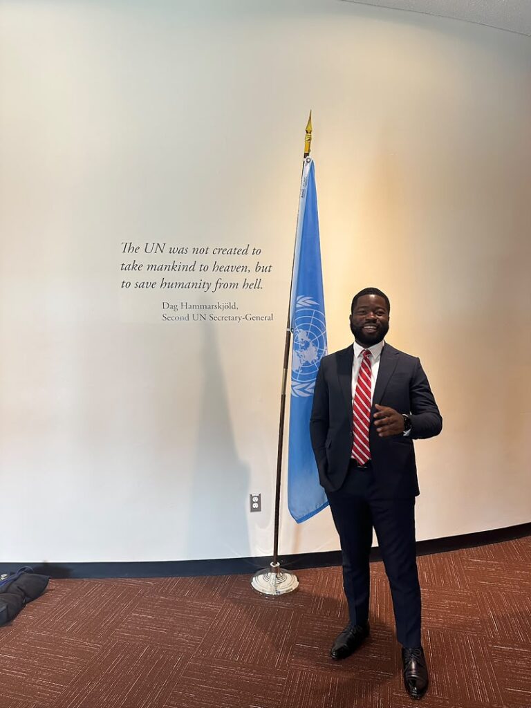 FDJ Senior Counsel Jacob Sule beside the United Nations flag at UN Headquarters in New York